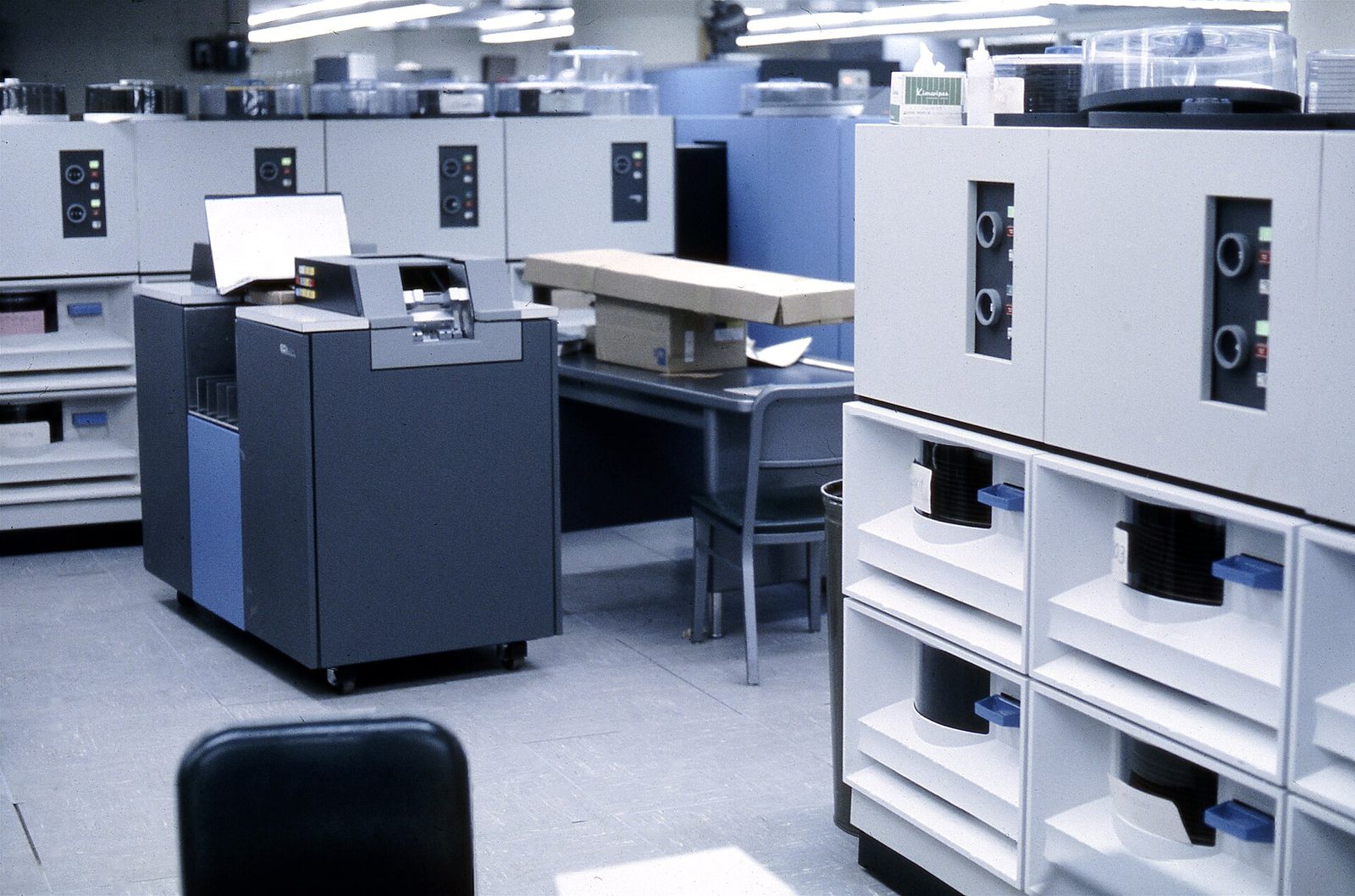 Řada diskových jednotek IBM 2314 s okénky, vedle snímač štítků