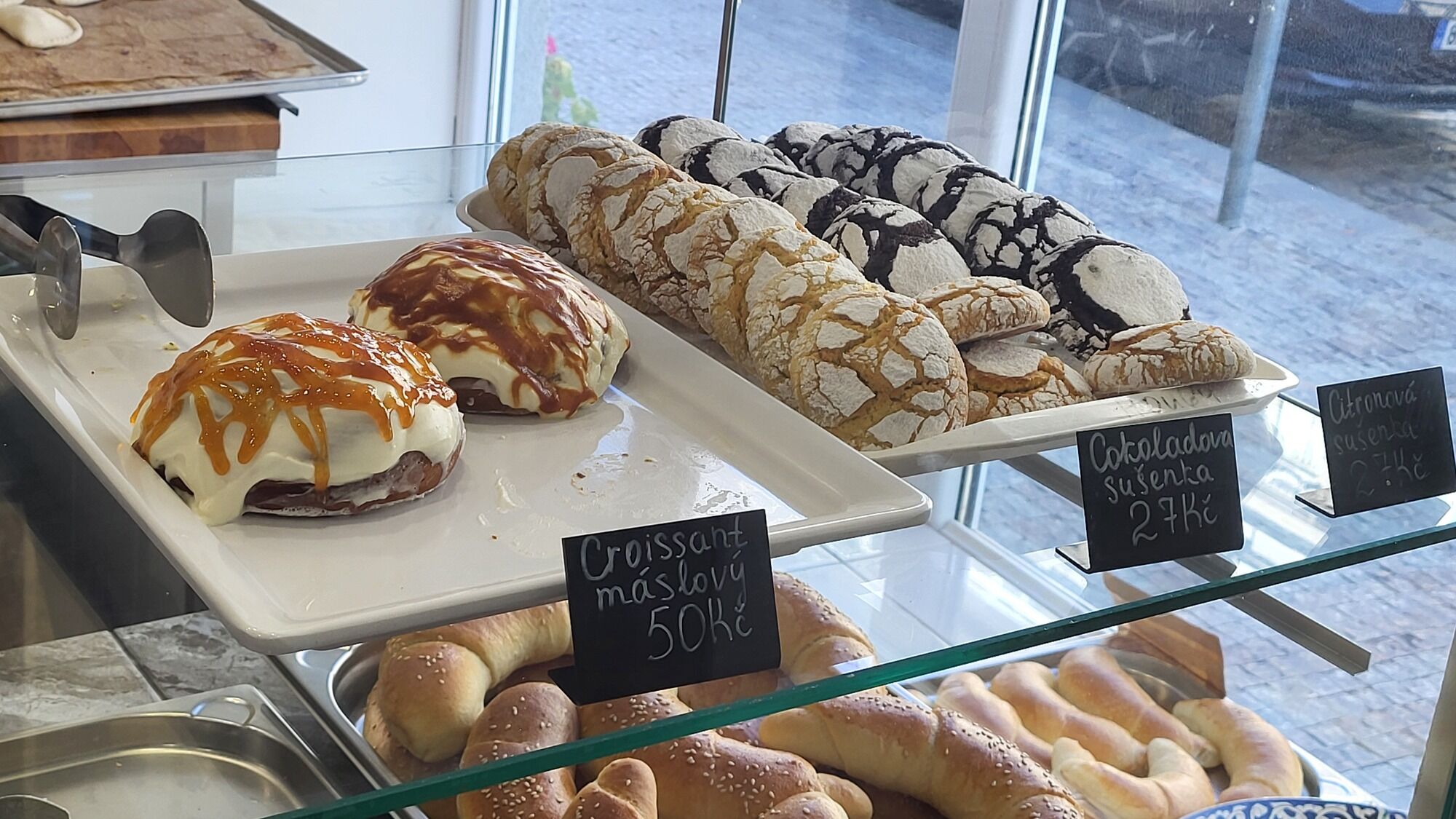 Vitrína pekárny Pánev: croissanty, popraskané sušenky a sezamové rohlíky