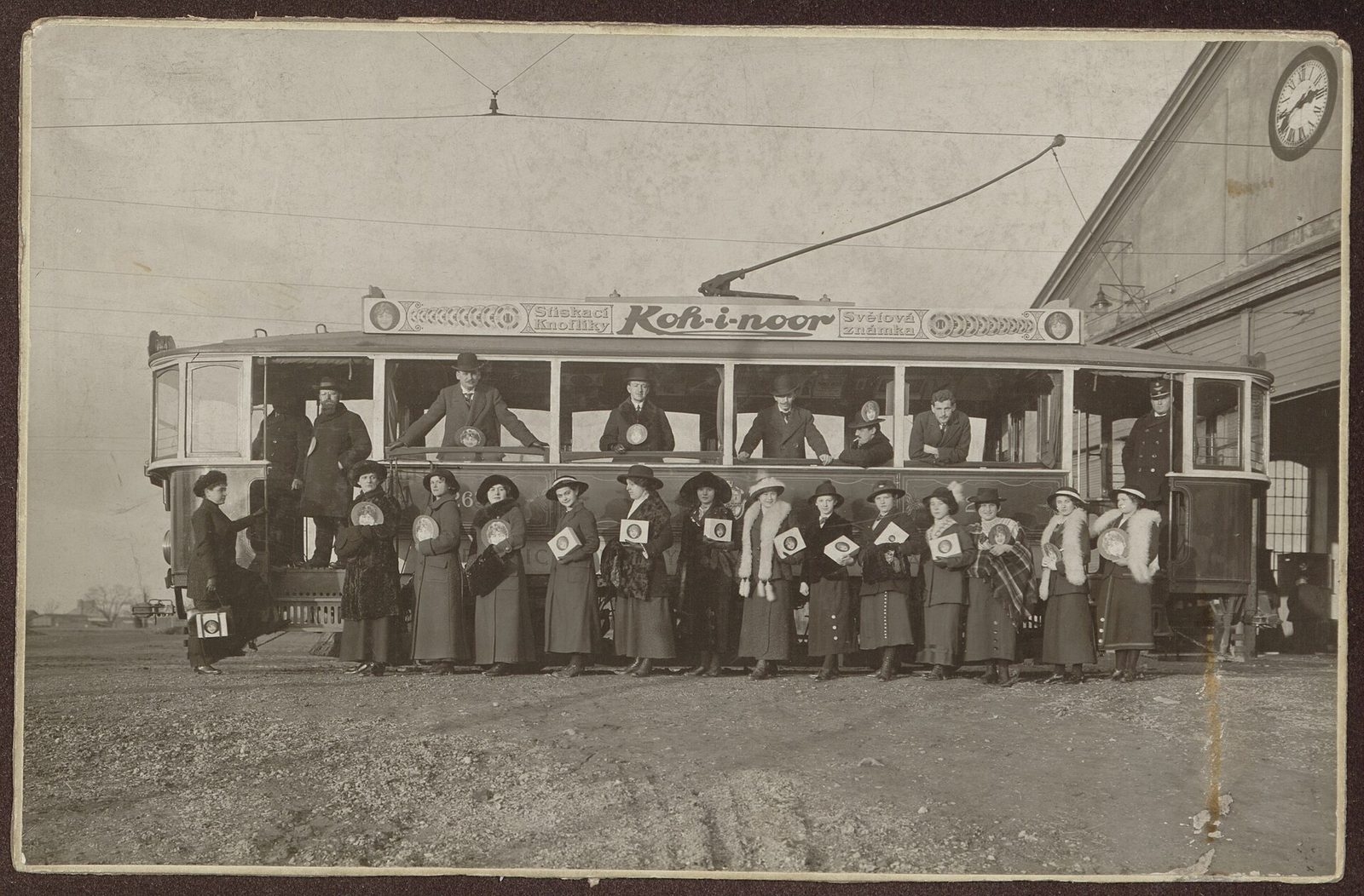 Tramvaj s reklamou Koh-i-noor a skupina žen s krabicemi patentek, 1913
